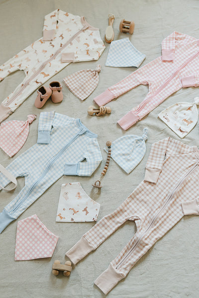 August & Ivy organic Pima cotton zip romper for babies, soft and comfortable with a front zipper and short sleeves.
