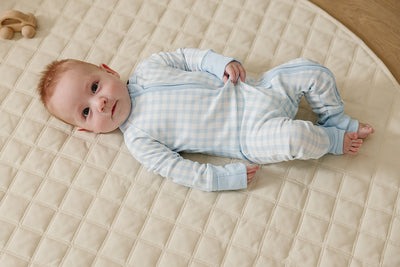 August & Ivy organic Pima cotton zip romper for babies, shown in soft fabric with a front zipper and snap buttons.