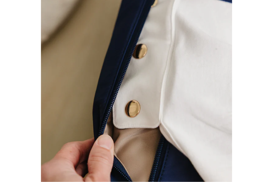 Hidden zippered compartment in the August & Ivy IvyGo diaper bag storing the snap-in nursing privacy cover.
